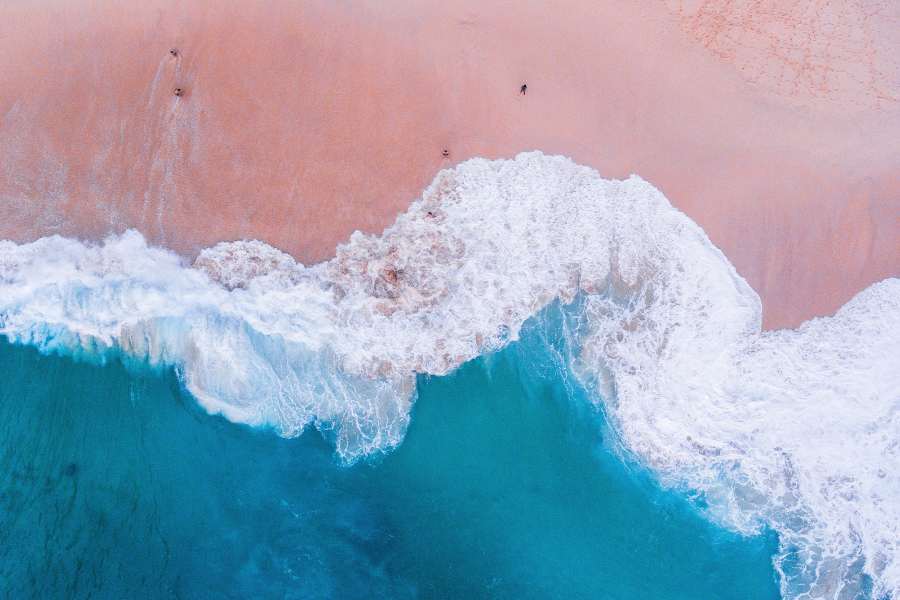 Bovenaanzicht van de zee met een roos strand